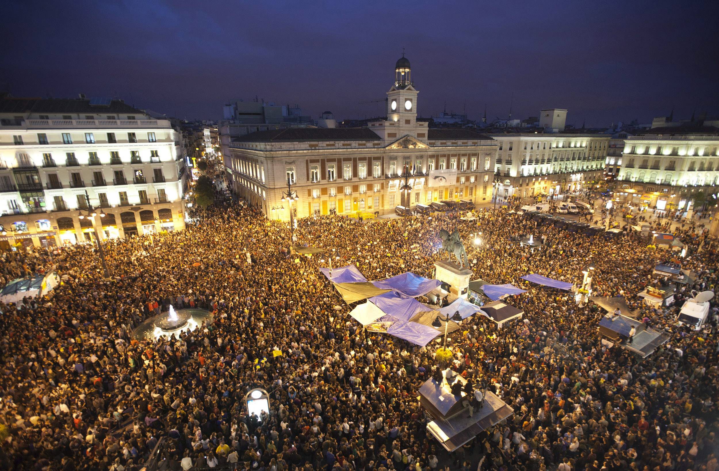 Demonstrators gather and shout slogans in Madrid's famous landmark Puerta del Sol